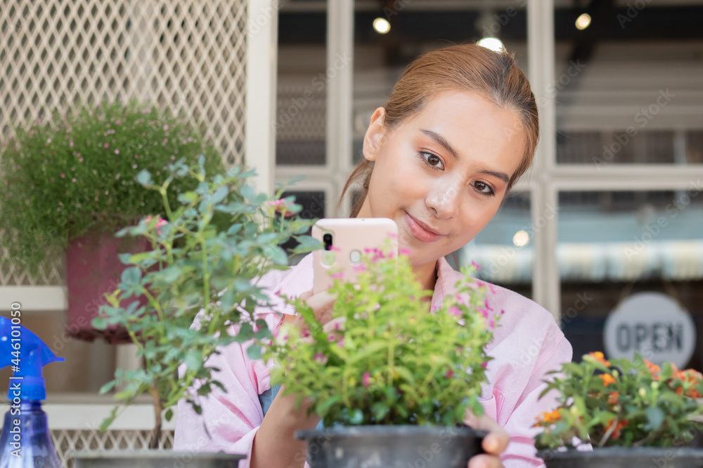 Smile, happiness of asian young woman, girl gardener using smartphone, take care flowers of pot plants, engaging hobby at home. Love gardening of plants and care. Owner small business concept.