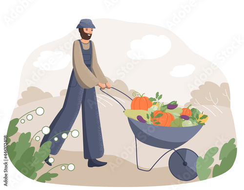 Happy adult man farmer pulls a cart with a bunch of fresh vegetables on the background of the field.