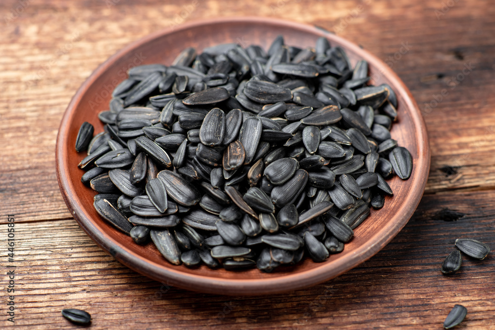 Black sunflower seeds on a wooden background.