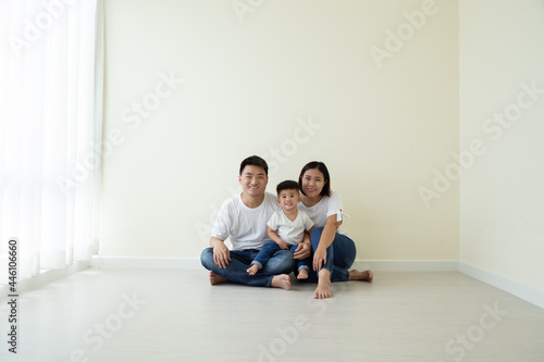 Asian family sitting on floor in the new room and new home, Relocation and real estate concept