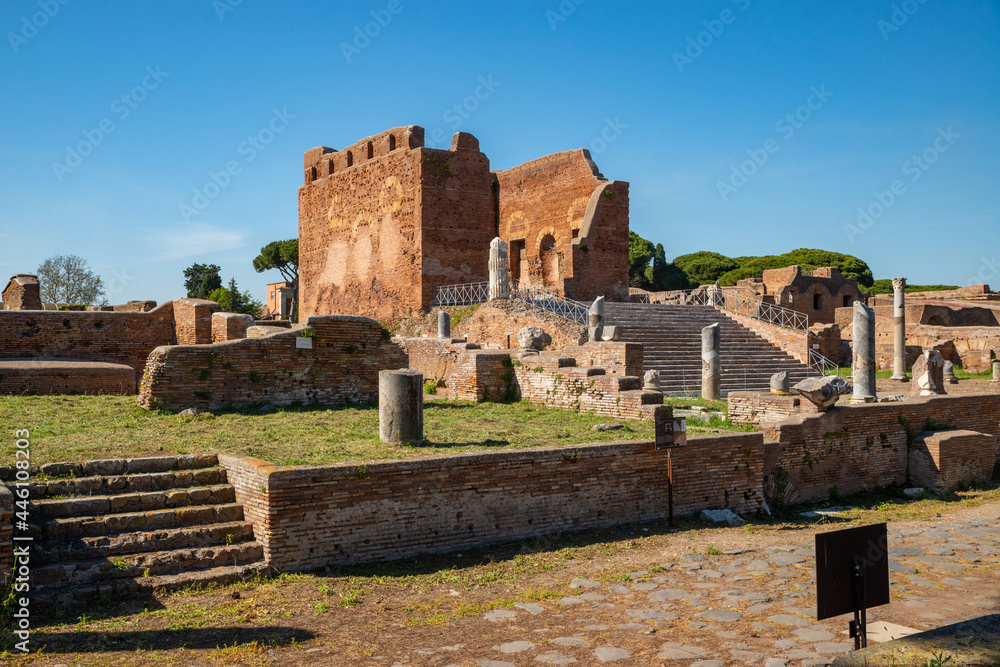 Ostia Antica archaeological site, view of the city forum with the Capitolium surrounded by marble columns, columns and remains of architecture. Ancient park ruins in summer, Italy.Europe.