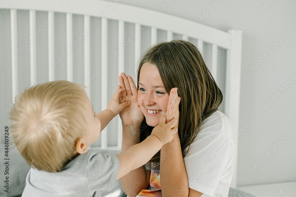 Younger brother and older sister spending time at home together. Friendly family, lifestyle concept. Younger brother and older sister spending time at home together. Friendly family, lifestyle concept.