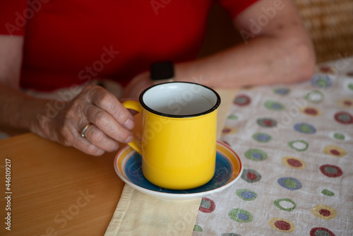 Senior woman holding a cup of morning coffee.