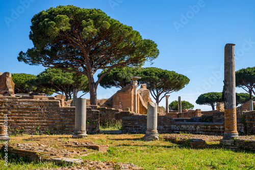 Rome Ostia Antica site, ruins of marble columns with brick buildings from the imperial era a in the archaeological park of Ostia Antica in summer with blue sky. Rome Italy, Europe. photo