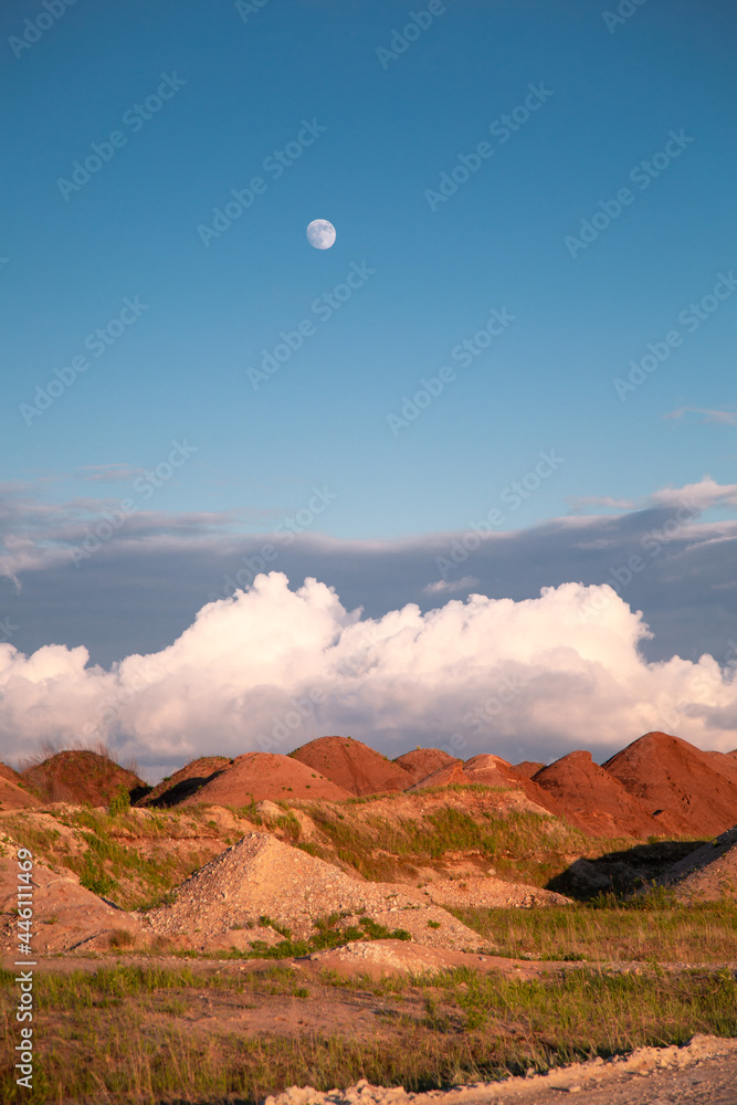 red valley in the desert with full moon sunset