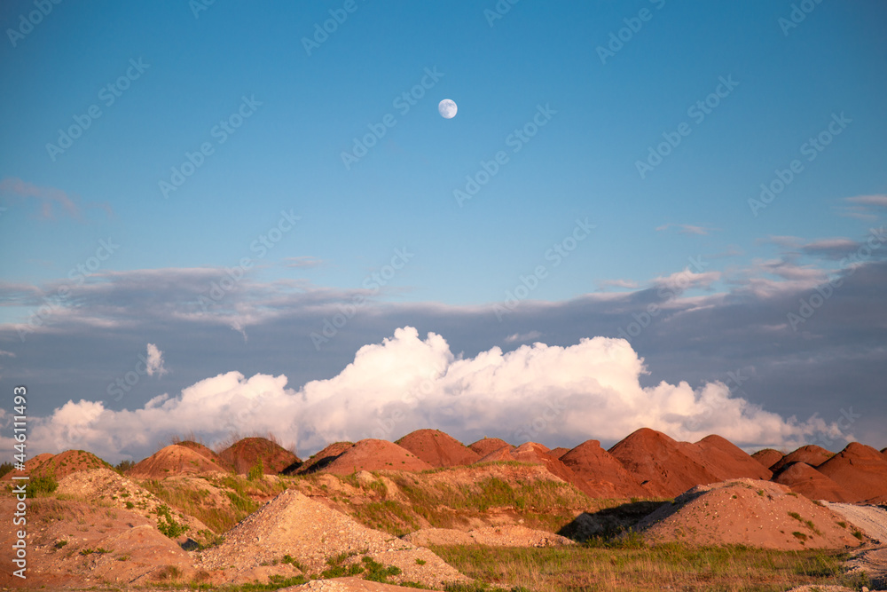 red valley in the desert with full moon sunset