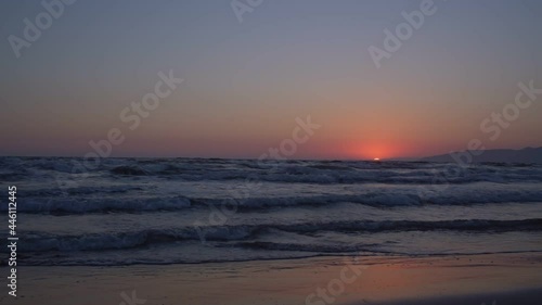 Wallpaper Mural Sunset of orange colour on horizon over endless sea with large waves silhouettes with sandy beach on foreground slow motion Torontodigital.ca