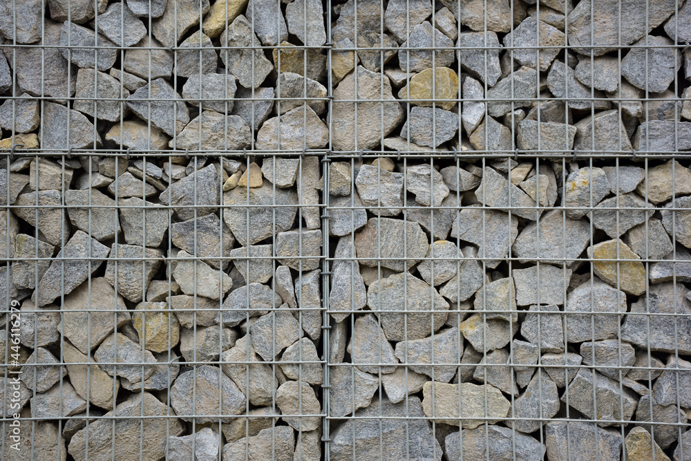 A large fence of many stone boulders supported by a stone trellis for the entire frame A large fence of many stone boulders supported by a stone trellis for the entire frame