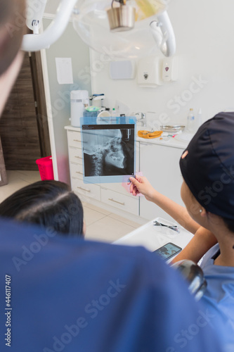 Young female dentist checking x-ray of a patient.