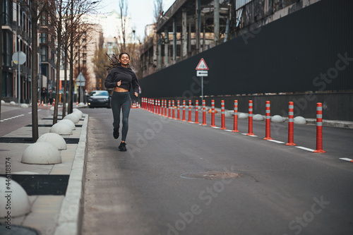 Wallpaper Mural Cheerful female jogger with cornrows running ahead Torontodigital.ca