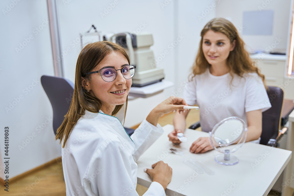 Cheerful ophthalmologist having appointment with patient in clinic