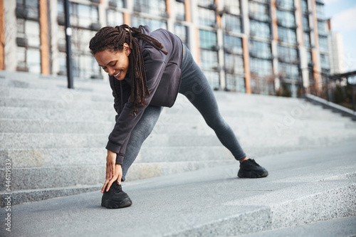 Sporty female with cornrows doing a stretching exercise