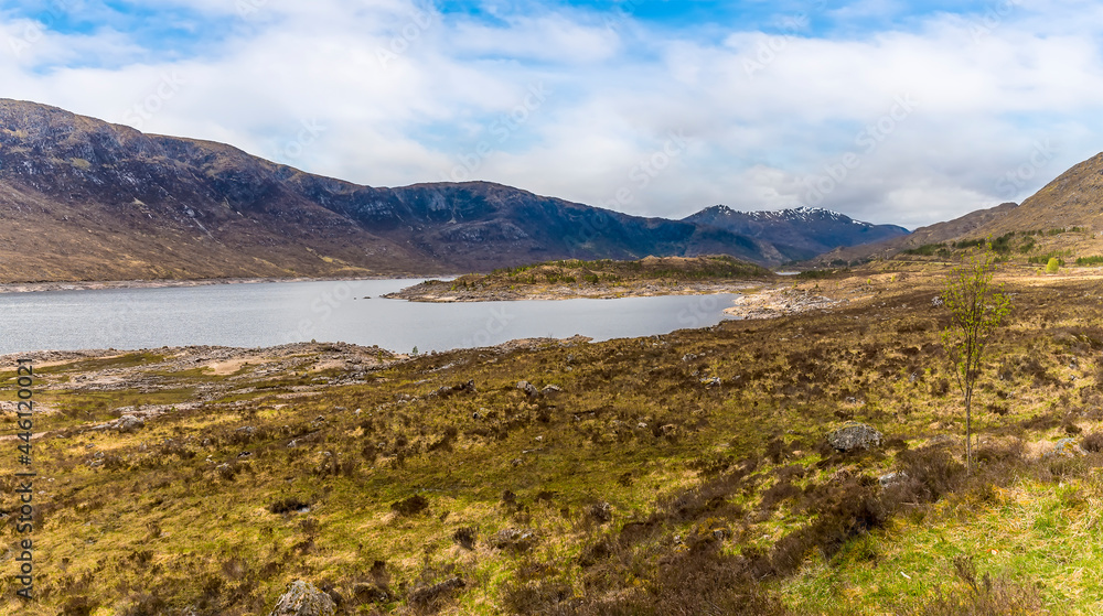 A view towards a small island along the shoreline of Loch Cluanie, Scotland on a summers day A view towards a small island along the shoreline of Loch Cluanie, Scotland on a summers day