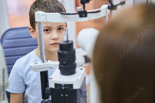 Adorable boy having eye examination in modern clinic