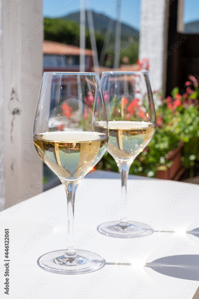 Obraz premium Summer on French Riviera Cote d'Azur, drinking cold dry white wine from Cotes de Provence on outdoor terrase in Port Grimaud, Var, France