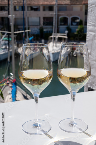 Summer on French Riviera Cote d'Azur, drinking cold dry white wine from Cotes de Provence on outdoor terrase in Port Grimaud, Var, France