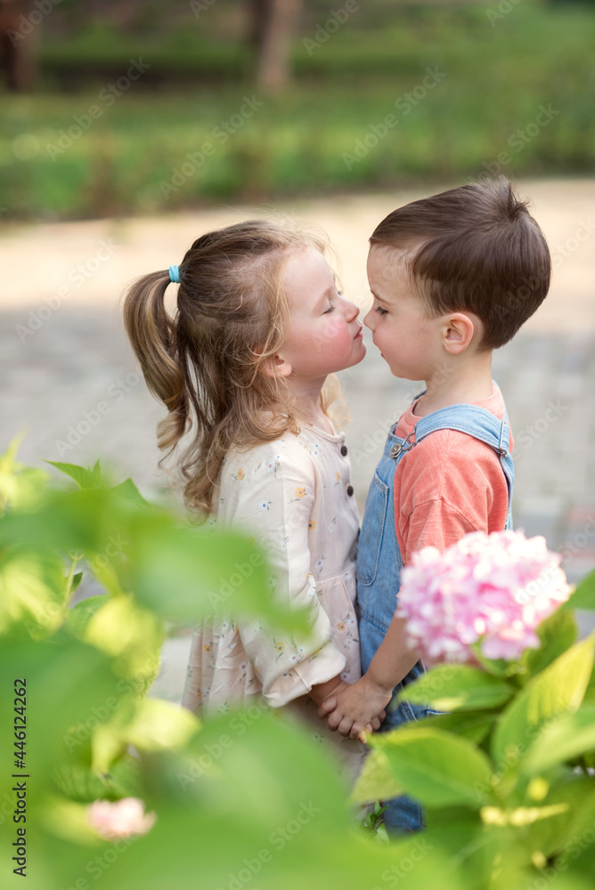 little boy and girl stand holding hands and kiss. Valentine's Day little boy and girl stand holding hands and kiss. Valentine's Day