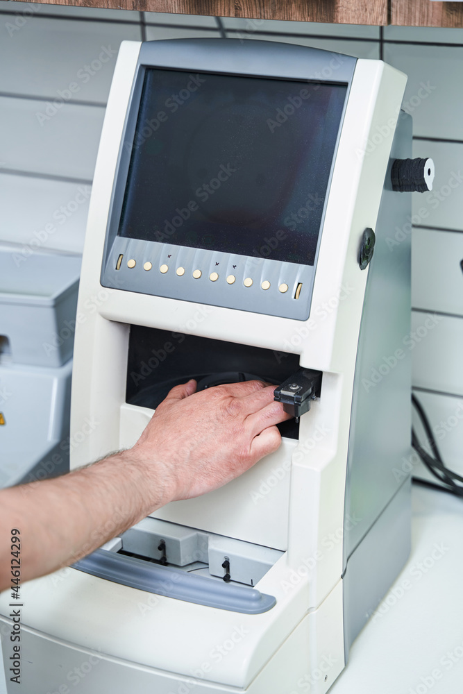 Male optician using optical equipment in workshop Male optician using optical equipment in workshop
