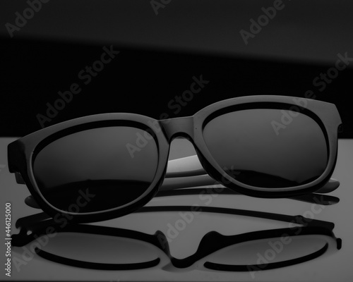 Cool sunglasses with black plastic frame on black background