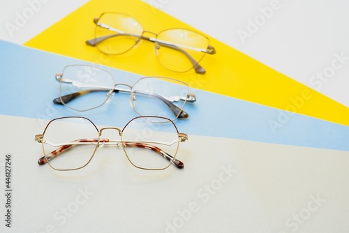 Stylish eyeglasses over background. Optical store, glasses selection, eye test, vision examination at optician, fashion accessories concept. Top view, flat lay