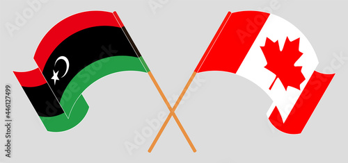 Crossed and waving flags of Libya and Canada