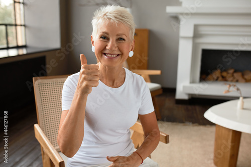 Attractive smiling senior lady shoring thumbs up, happy with life, good mood. Mature woman express love for life, value every moment. Appreciation, emotion, lust for life concept. Copy space