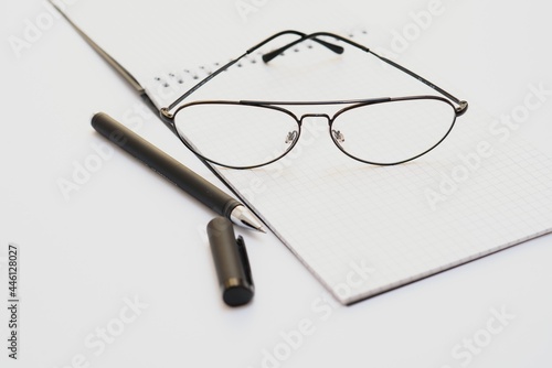 opened notebook with pen and glasses isolated