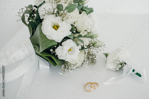 wedding bouquet and rings on white background