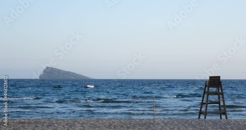Lifeguard chair on the beach with boat and island in the background
