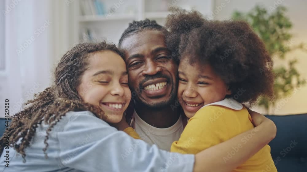 Happy little sisters kissing cheeks of loving father, family hugging and smiling Happy little sisters kissing cheeks of loving father, family hugging and smiling