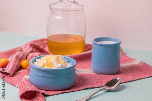Cottage cheese in a blue bowl with sour cream and honey. Morning breakfast.