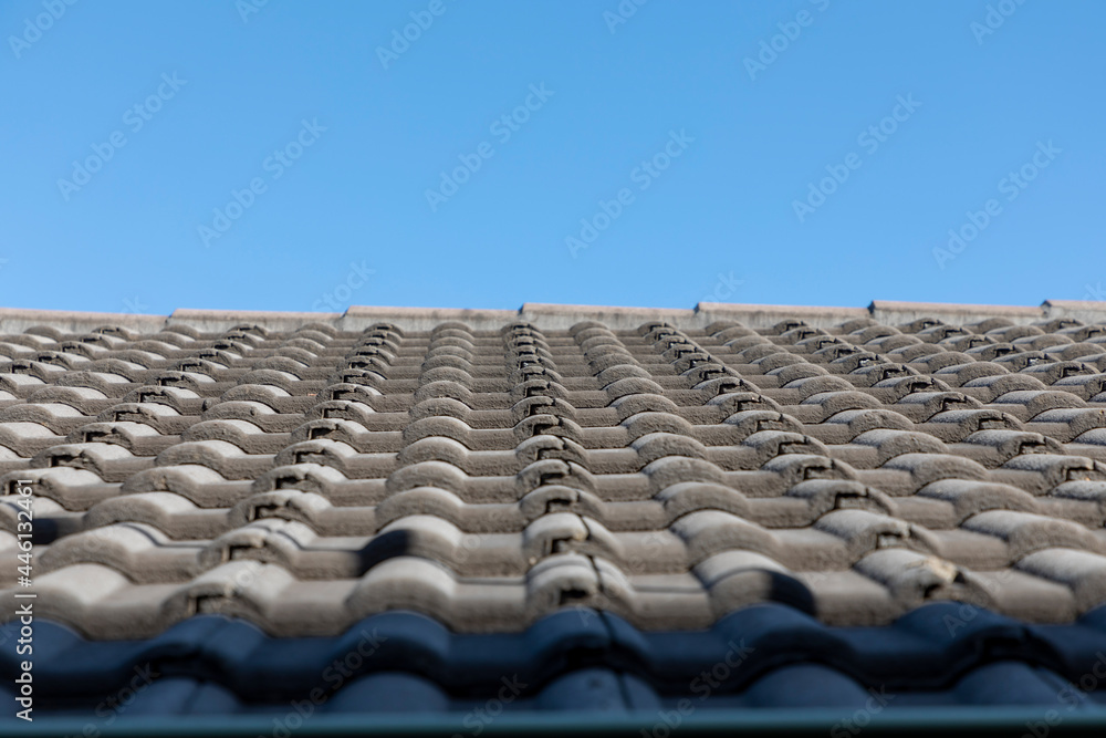 Grey terracotta roof tiles in a line on a roof