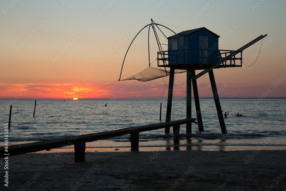 Cabane au bord de la plage avec un coucher de soleil