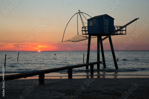 Obraz na plátně Cabane au bord de la plage avec un coucher de soleil