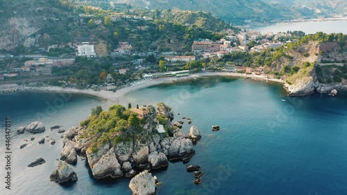 Aerial view of Isola Bella near Taormina travel destination in Sicily, Italy. flying over drone high angle shot of iconic mediterranean sea town coast line. Aerial sunset cityscape