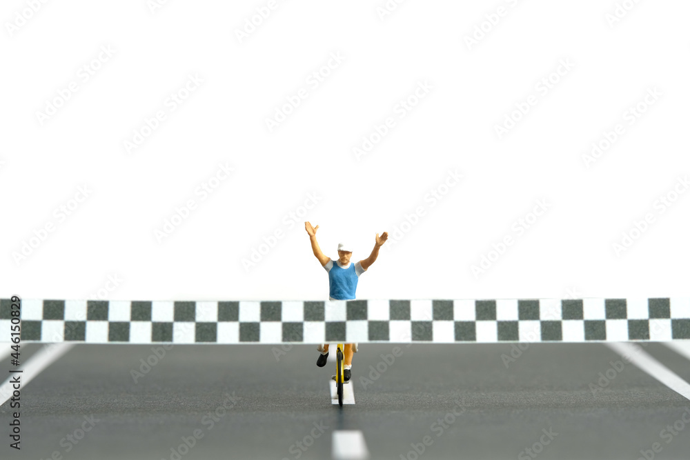 Miniature people toy figure photography. A biker with finish line, completed the bike competition, isolated on white background. Miniature people toy figure photography. A biker with finish line, completed the bike competition, isolated on white background.
