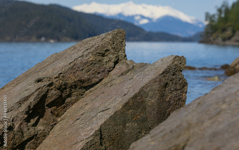 Beautiful landscape of the rocky shore and mountains on the island at the Harrison Lake, BC.