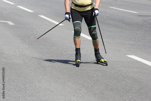 sportsman roller skis on the asphalt on the city road. Sports leisure