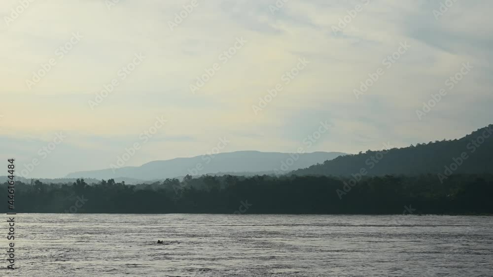 A boat seen crossing diagonal wise the Mekong River from Thailand side to Laos during the early part of the day. A boat seen crossing diagonal wise the Mekong River from Thailand side to Laos during the early part of the day.