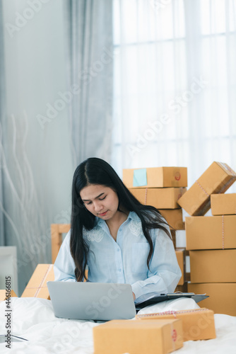 young woman person packing product to a delivery box, female business owner entrepreneur are happy with online e-business at home © chokniti