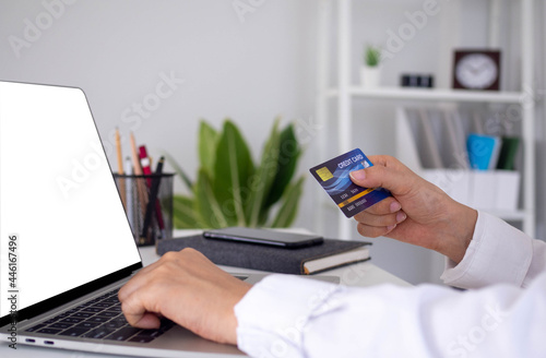 The woman enjoys shopping online via a computer and paying online via credit card. Convenience of spending without cash. stay safe, shopping from home and Social distance