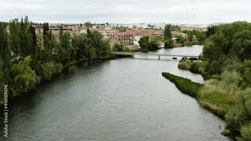 Aerial View Of Bridge Over Tormes River Along Soto Island And Town In Salamanca, Spain. - forward photo