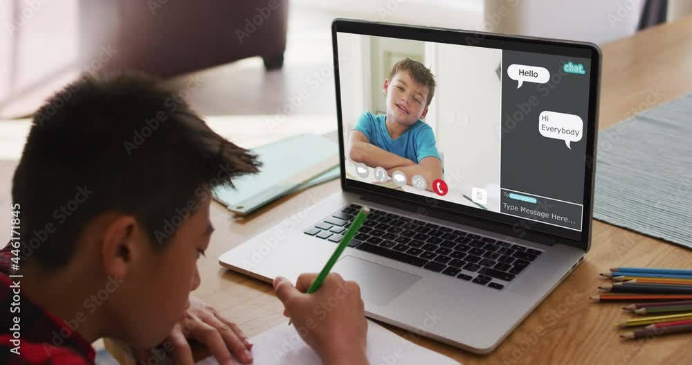 Schoolboy using laptop for online lesson at home, with school friend and web chat on screen Schoolboy using laptop for online lesson at home, with school friend and web chat on screen
