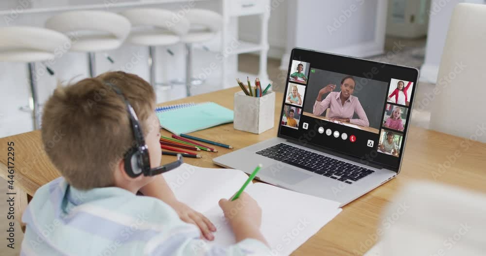Schoolboy using laptop for online lesson at home, with diverse teacher and class on screen Schoolboy using laptop for online lesson at home, with diverse teacher and class on screen