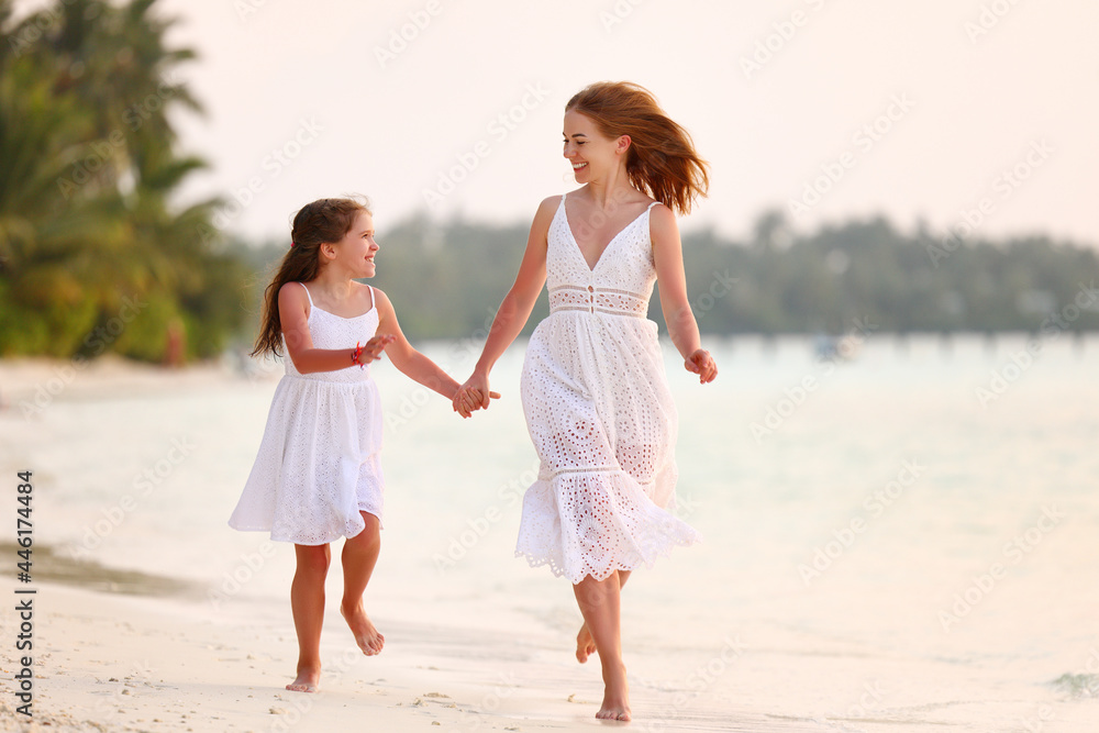 Happy family mother and daughter running in beach