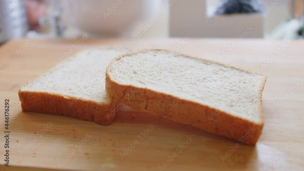 close up fresh Sliced bread falling in slow motion onto wooden table at the kitchen, breakfast food in the morning close up fresh Sliced bread falling in slow motion onto wooden table at the kitchen, breakfast food in the morning