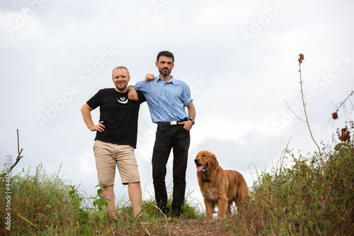 Two Caucasian hipsters outdoors with dog, friendship