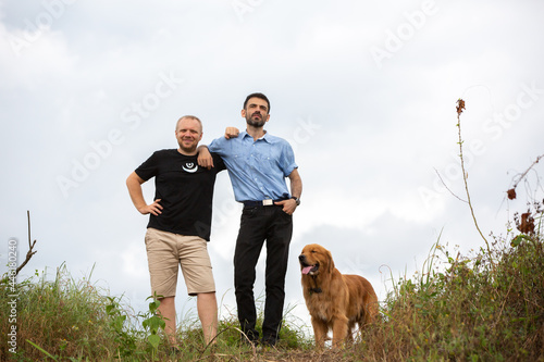 Two Caucasian hipsters outdoors with dog, friendship