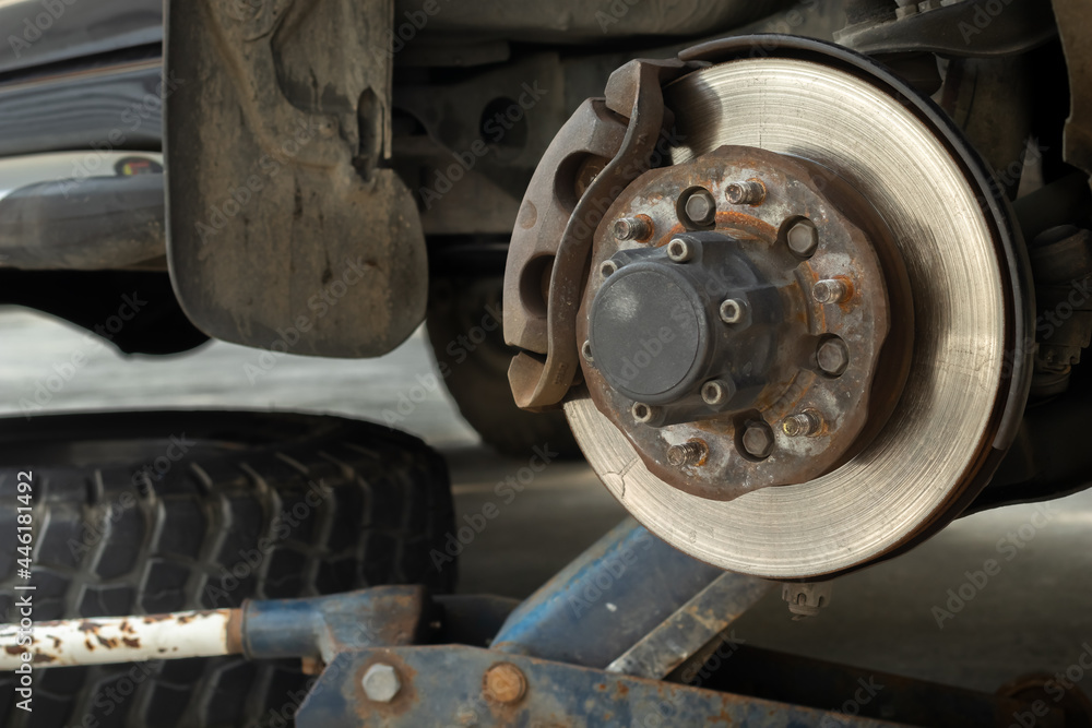Close up scratched textured disc brake and wheel hub of the 4x4 car after longtime using waiting