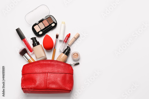 Bag with makeup supplies on white background